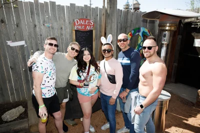 Six friends pose together in front of a wooden fence at Bunny Hop.