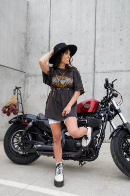 Cintia Lastra posing next to a red and black Harley Davidson.