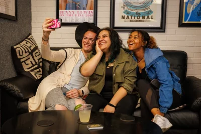 (L–R) Josh Grant, Monica Lissette and Cassidy Hammond take a few selfies before Lissette picks up the mic and drops her poems. She’ll deliver some “spicy” takes on the Chicana experience and on women in general as they navigate the world. Grant finds a lot of “realism” in Lissette’s poetry.