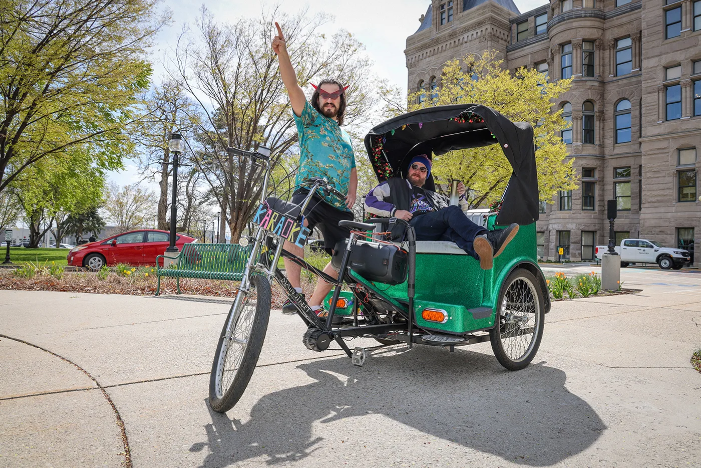 (L–R) Local pedicab peddler Pat Horn and Mike Brown take a ride through the city.