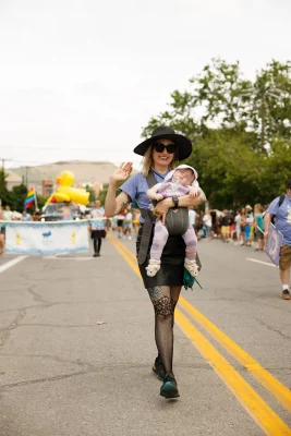 Executive Editor at SLUG Magazine, Angela Brown, with baby Esmé in tow walking in the Utah Pride Parade.