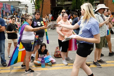 Managing Editor of SLUG, Audrey Lockie, handing out copies of SLUG's Pride LGBtQ+ Issue along the route of the 2022 Pride Parade.