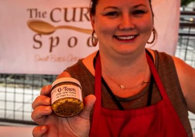 Valerie of The Curvy Spoon holds up a jar of O-Towns whole grain mustard