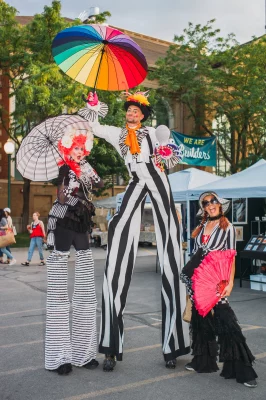 (L-R) Stiltwalkers Heidi Butterfly, Chad Rockstar and Leggy Meggy with their simultaneously monochrome and colorful performance. (Photo: @clancycoop)
