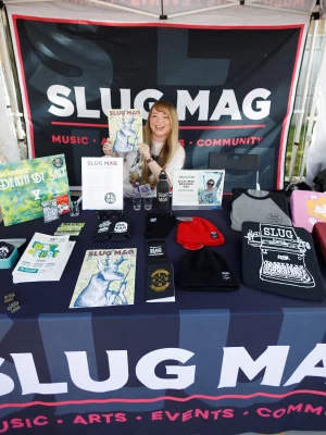 Lovely Lexi Kiedaisch manning the SLUG Mag booth and all its fun merch!
