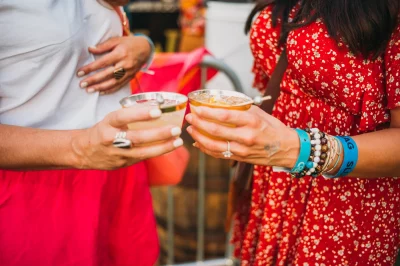 Two attendees toast each other with drinks from Clear Water Distilling Co. along with the handmade jewelry they purchased just before at the event. (Photo: @clancycoop)