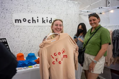 Two ladies smile with Mochi Kids apparel at DIY Fest