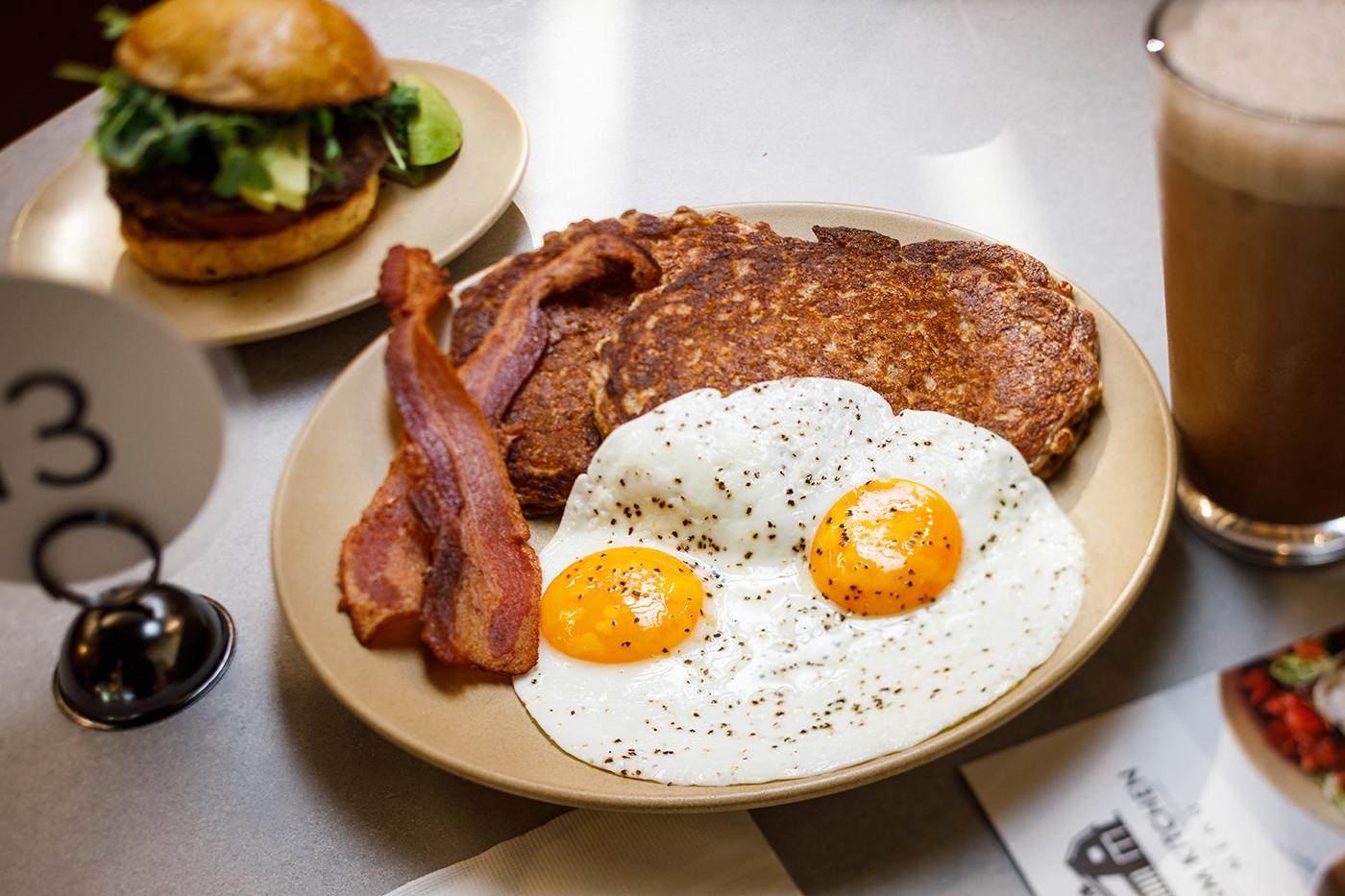 Redmond Farm Kitchen offers seasonal produce, farm-fresh eggs, dairy and meat year round at their Farm Stores in Sugarhouse, Orem and Heber City. Pictured is the Farm Boy: uncured bacon, organic eggs, and syrup drizzled over oatcakes with raw farm-made butter accompanied by a glass of Raw Chocolate Milk.