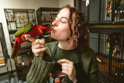Victoria Barrie shares a kiss with one of Traci's Parrots 4U's many colorful birds.