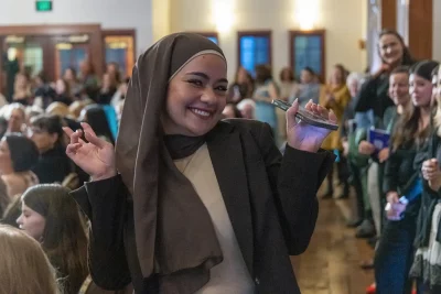 Nour returns to her seat after cheering for her mom, Kholoud, who just finished a run on the catwalk in a Syrian abaya. Photo: John Barkiple