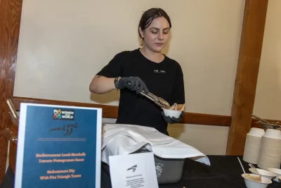 Ashley from Mazza prepares lamb meatballs with a tomato-pomegranate sauce at the Women of the World Annual Fashion Show and Cultural Gala. Photo: John Barkiple
