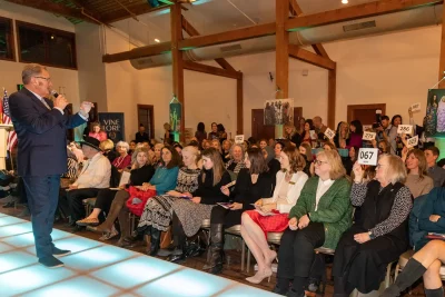 Each raised bid card represents a speed-round donation collection at $100 a pop. Photo: John Barkiple