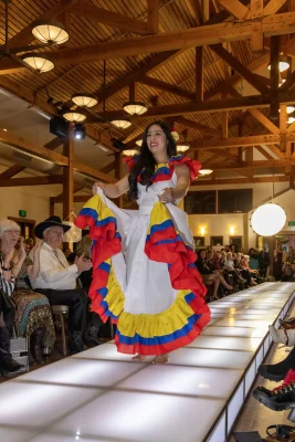 Michelle from Colombia waves the hems of her cumbia dress as she finishes her lap on the runway. Photo: John Barkiple