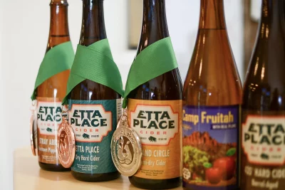 Five Etta Place ciders sit close to the camera. The leftmost three have medals on them. Photo: Em Behringer