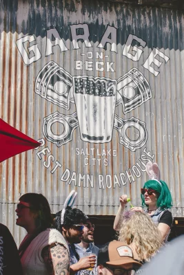 The photo depicts a group of people wearing bunny ears. Above them is a large mural reading "GARAGE".