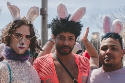 The picture shows three people in bunny ears. The one on the left is wearing a sequined top, the one in the middle a pink fishnet top and the one on the right is wearing a plain t-shirt.