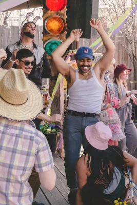 Picture of a person in a wife beater and blue baseball cap dancing.