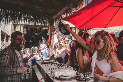 Picture of an attendee in a white top fanning the DJ.