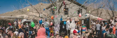 A panorama of attendees at Bunny hop. In the middle of the pano is a tree decorated with plastic Easter eggs.