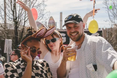 Group of three people at the hop. Two are wearing bunny ears, and one is holding a drink in their hand.