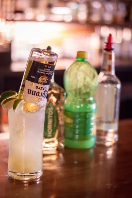 A bottle of Corona sits neck down in a glass on a bar. Photo: Katerina Duerr