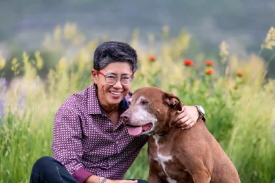 Jenifer Nii sits in a field with her dog. Photo courtesy of Kylan Brown.