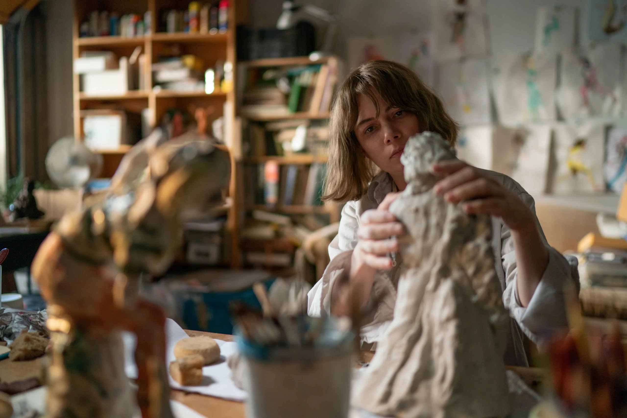 A woman (Michelle Williams) sculpts in her apartment in a scene from Showing Up.