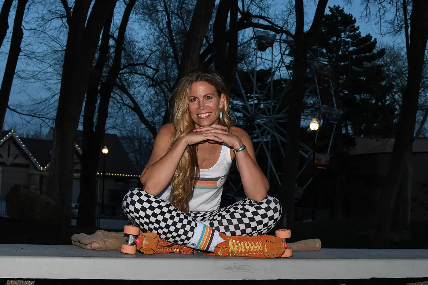 Elise Jones sits on a park bench lit by a camera flash. She is dressed in sporty, vintage clothing. Photo: Jovvany Villalobos