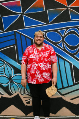 Nuanua Collective Director Jakey Sala Siolo stands in front of a mural. Photo: Em Behringer