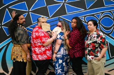 L–R Ma’afu Suliafu, Jakey Sala Siolo, Angela Robinson, Isaiah Asiata and Anita Uhi stand in front of a mural together looking toward the camera over their shoulders. Photo: Em Behringer