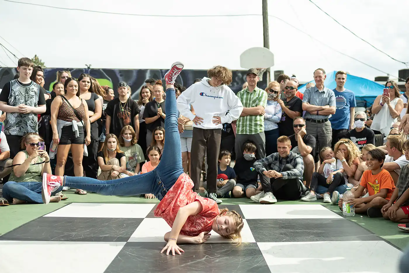 A crowd surrounds a young breakdancer mid dance. Photo courtesy of 1520 Arts.