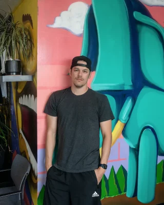 Executive director Joshua Perkins stands in front of one of the many murals at The HERC. Photo: Justin Lagman