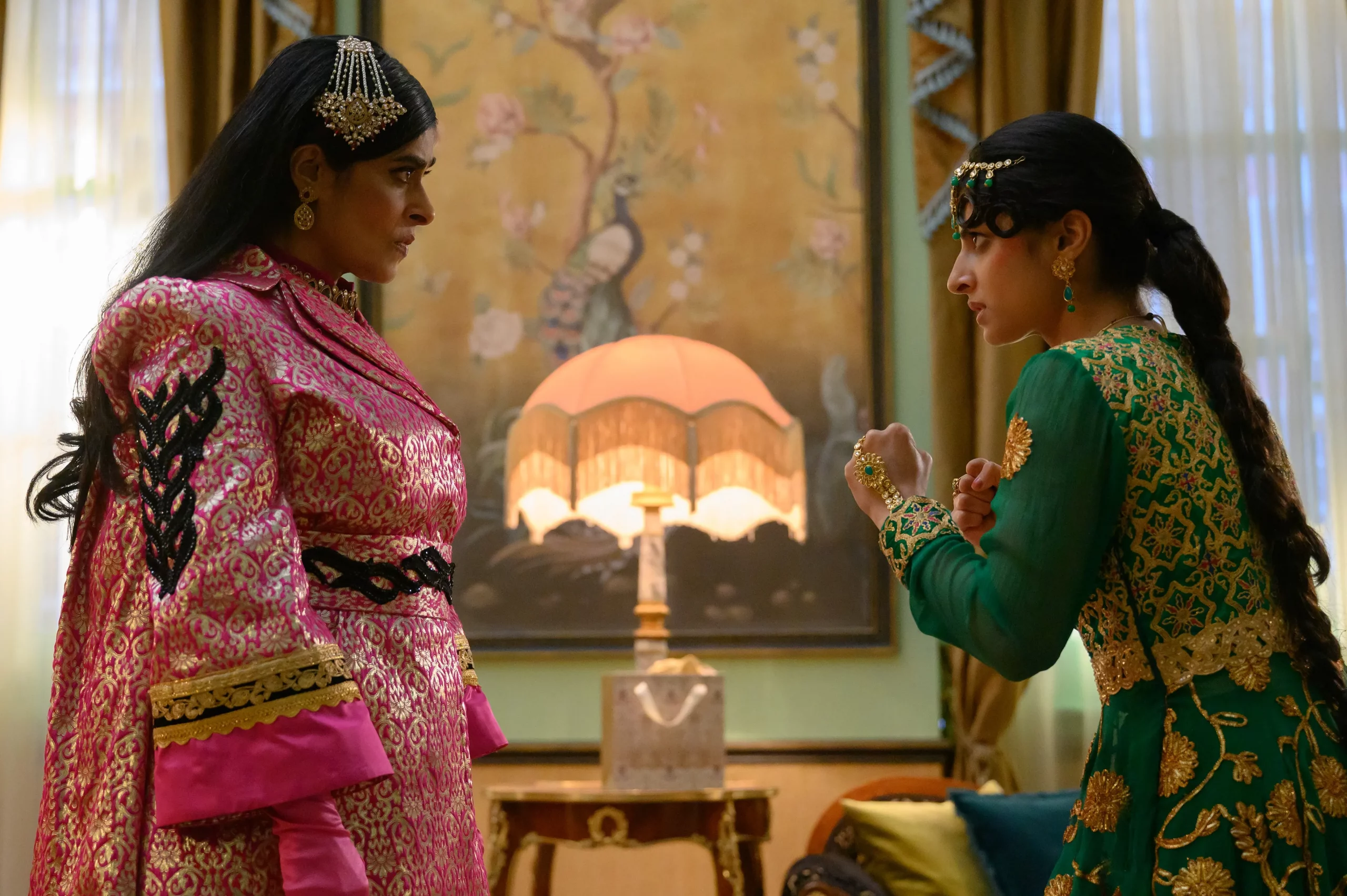 Two women stand facing each other, one with her fists up as though she's about to fight.