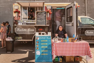 A food truck with a table and menu set up outside.