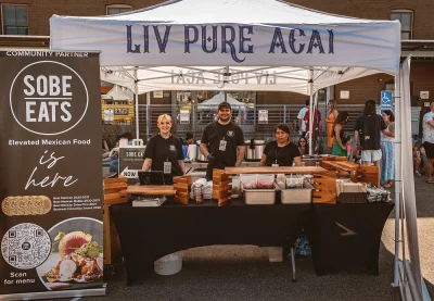 Three people working the Live Pure Acai tent.