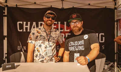 Two people working the Chappell Brewing tent.