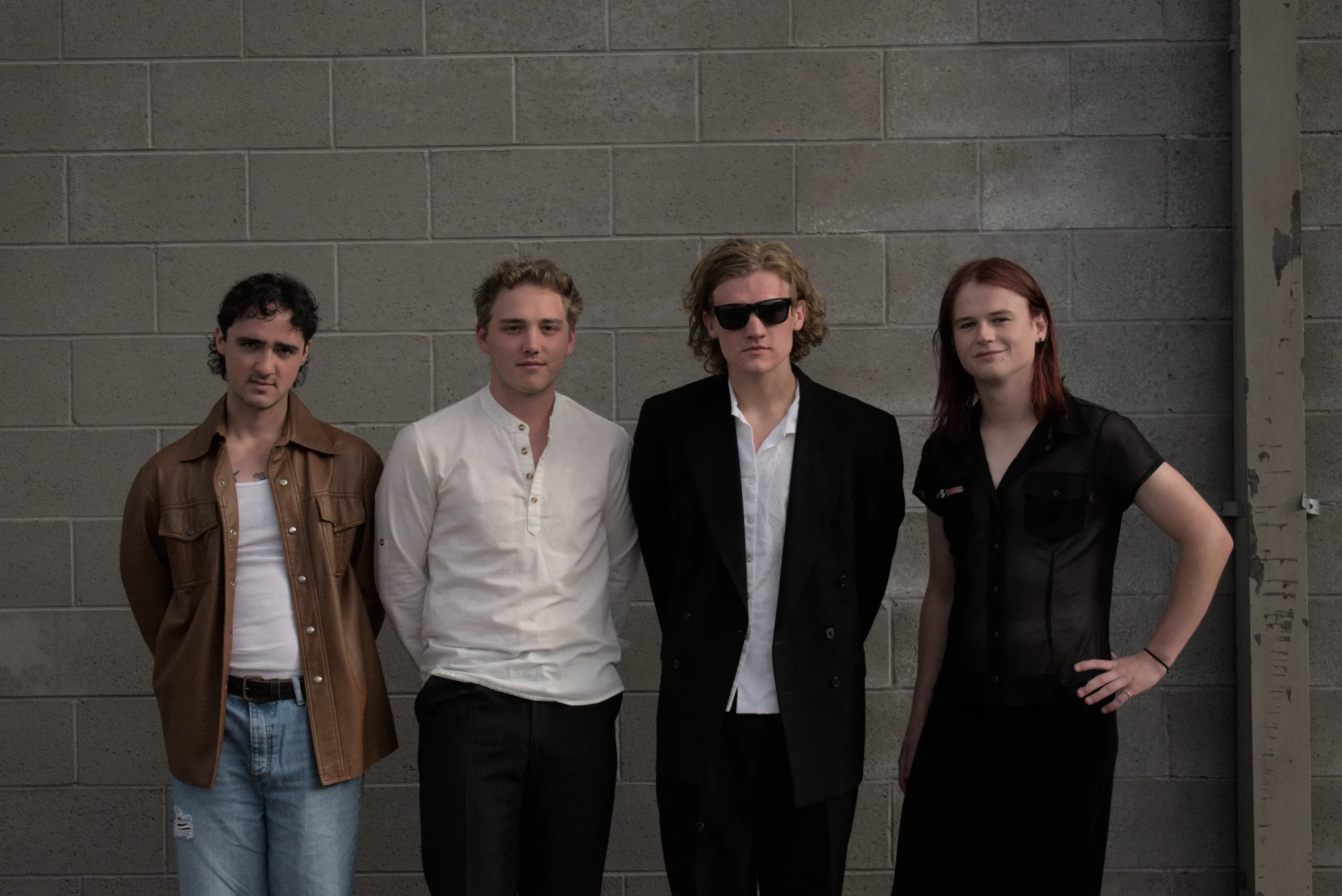 Michael Bloom, Landon Langenbrunner, Che Landikusic and Ryan Ross stand together in front of a gray brick wall.