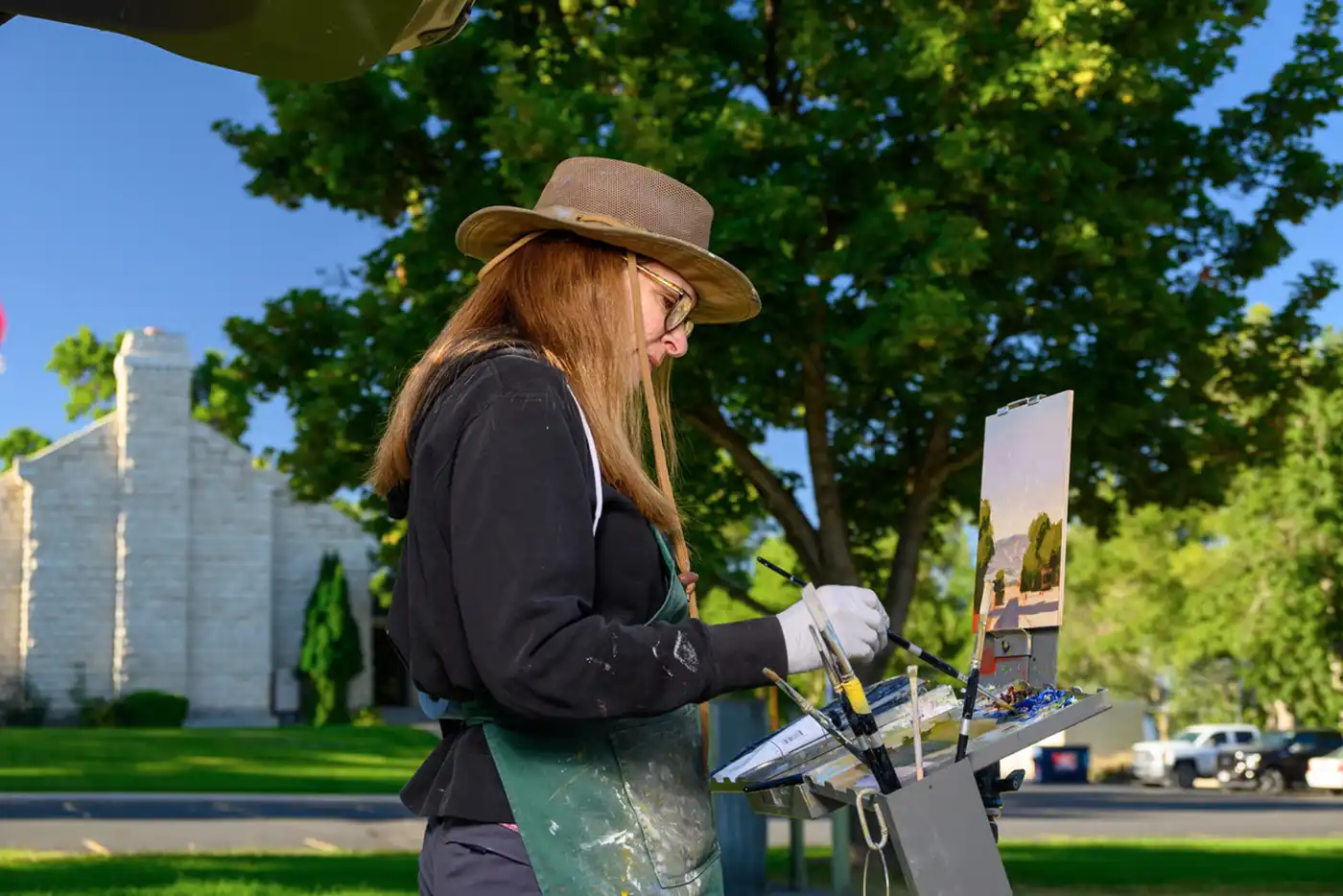 Jane Anne Woodhead works on her painting Sanpete Sky, capturing life “out of doors” in the Spring City Plein Air Painting Competition.