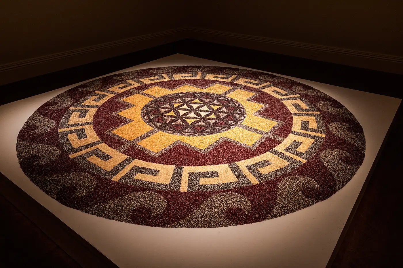 Large, circular mandala design on the floor made of individual corn kernels. Photo courtesy of UVU Museum of Art