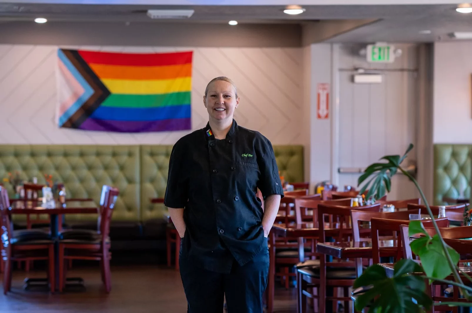 Felicia Hanson, owner and chef at Sweet Hazel and Co. Bakeshop and Bistro, stands in front of an LGBTQ Pride flag at the restaurant.