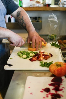 Max Nelson chops brussel sprouts, peaches and beets for Central 9th Market's Stone Fruit Salad. Photo: Em Behringer