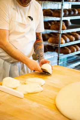 Head of fermentation Neil Hopkins shapes bread dough.