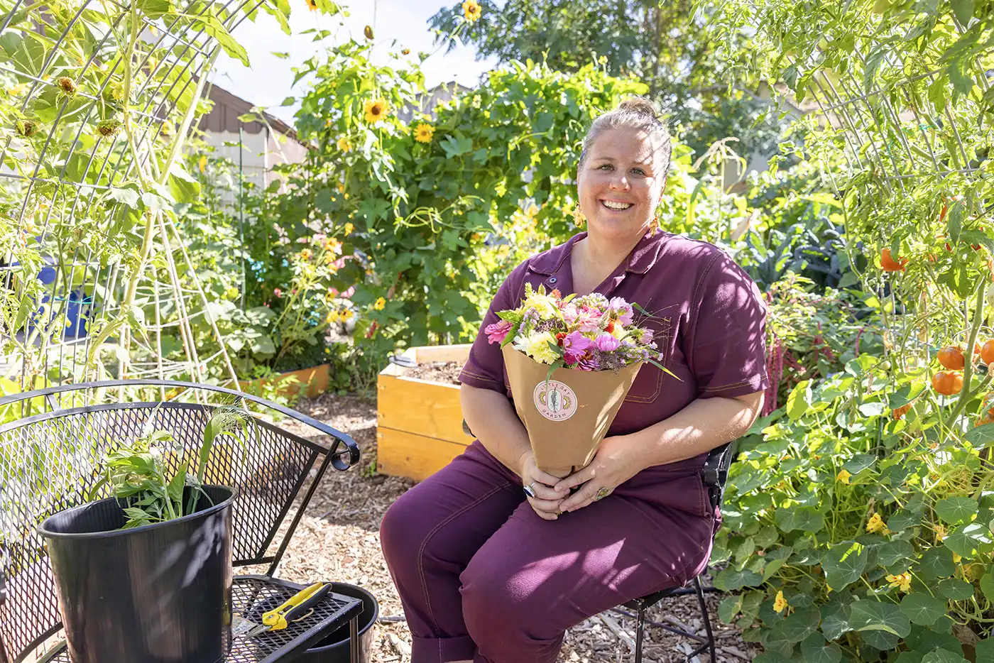 June Hyatte sits in her garden with a bouquet of flowers.