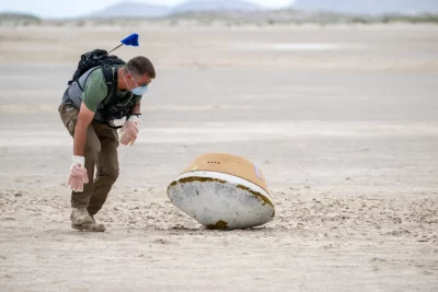 A military representative checks a rehearsal capsule for unexploded ordinance. Photo courtesy of NASA/Keegan Barber