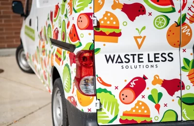 A van bearing the Waste Less Solutions logo and a collage of illustrated food. Photo: Ashley Christenson