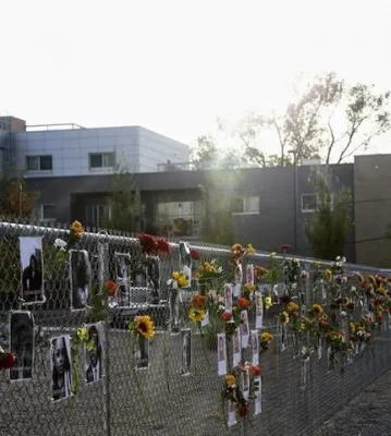 Photos and flowers adorn a fence at the Say Their Names memorial.