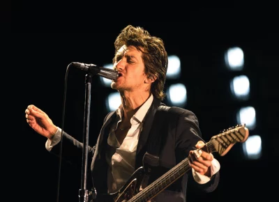 Alex Turner singing closely into the microphone.