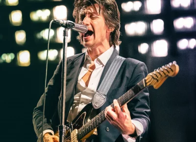Alex Turner singing and playing guitar during the Arctic Monkeys show at the Delta Center.