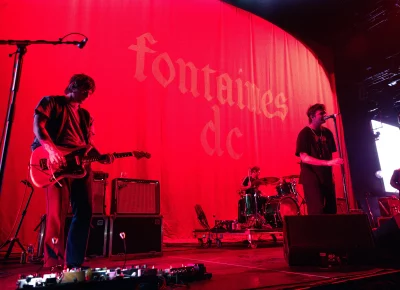 The band Fontaines D.C. playing their set under red lighting.