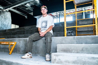 Jake Reedy sits on a concrete structure.